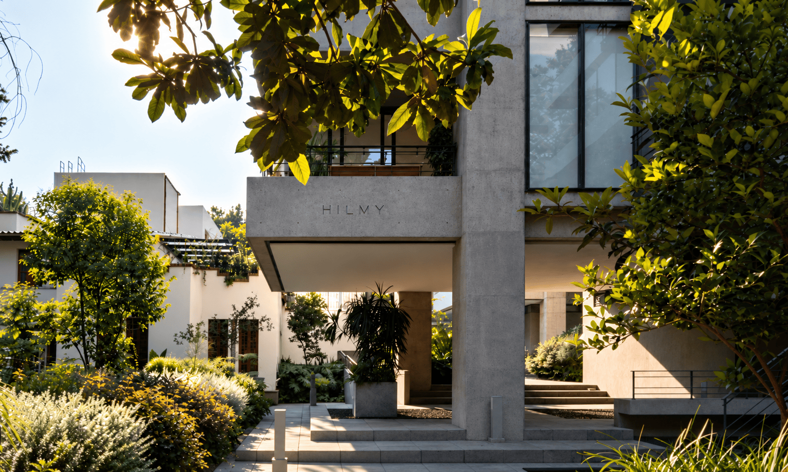 La oficina de HILMY en Ciudad de México: arquitectura de concreto dentro de un patio con vegetación.