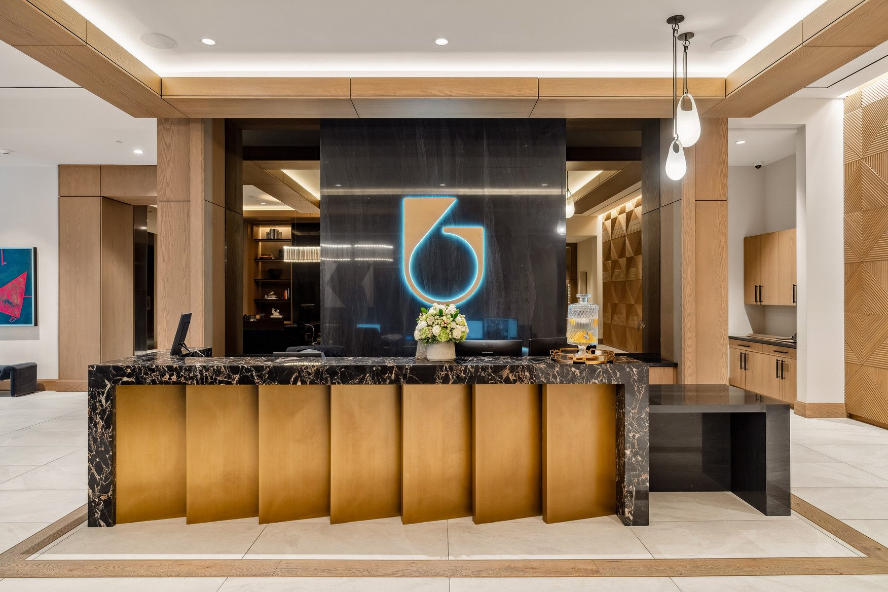 Lobby and reception at Residences at 6G, the illuminated 6 mark on the wall behind the desk
