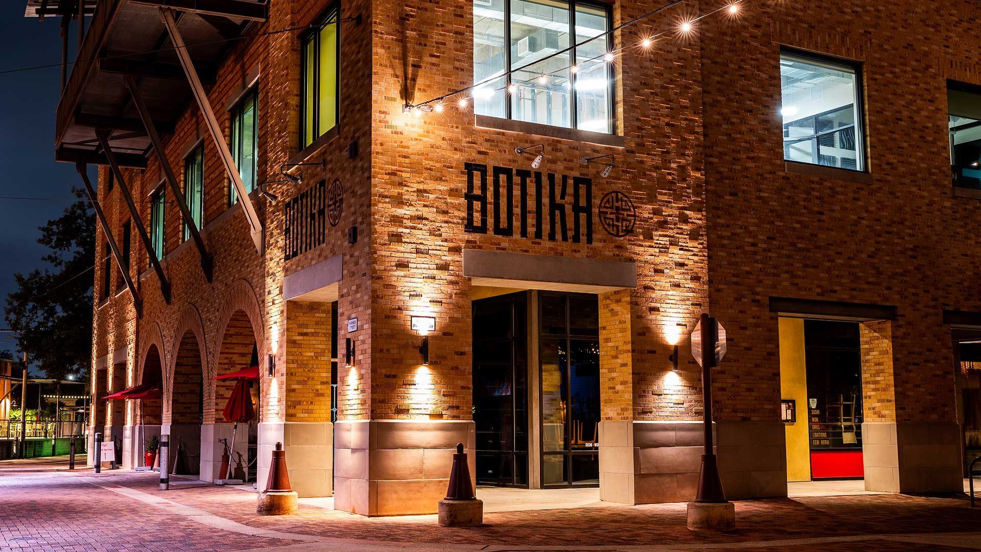 The Botika signage on the brick facade at night