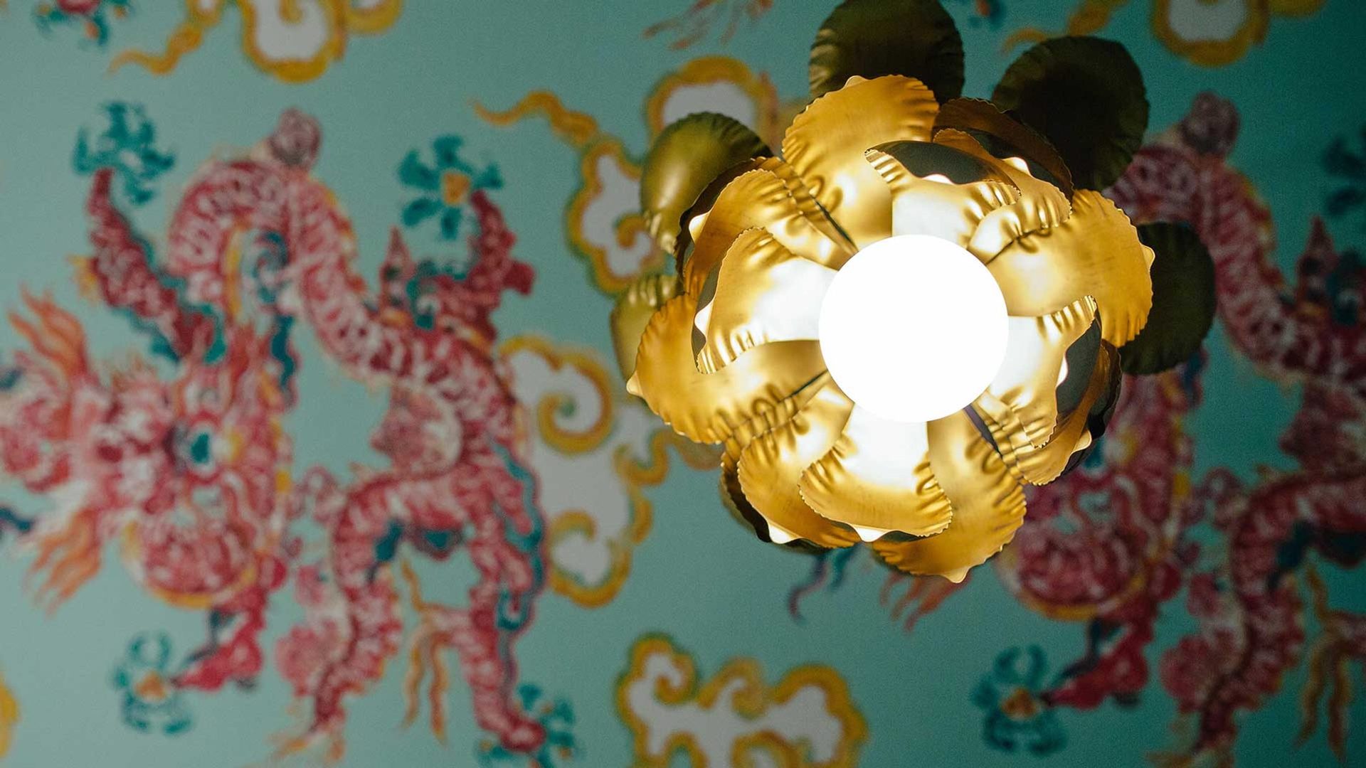 A brass fixture against the printed dragon wall