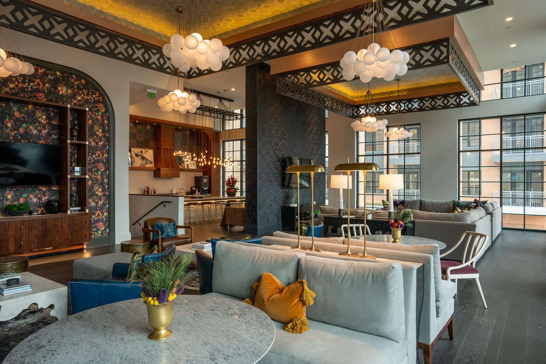 Resident lounge with clustered white globe pendants and a floral wall treatment