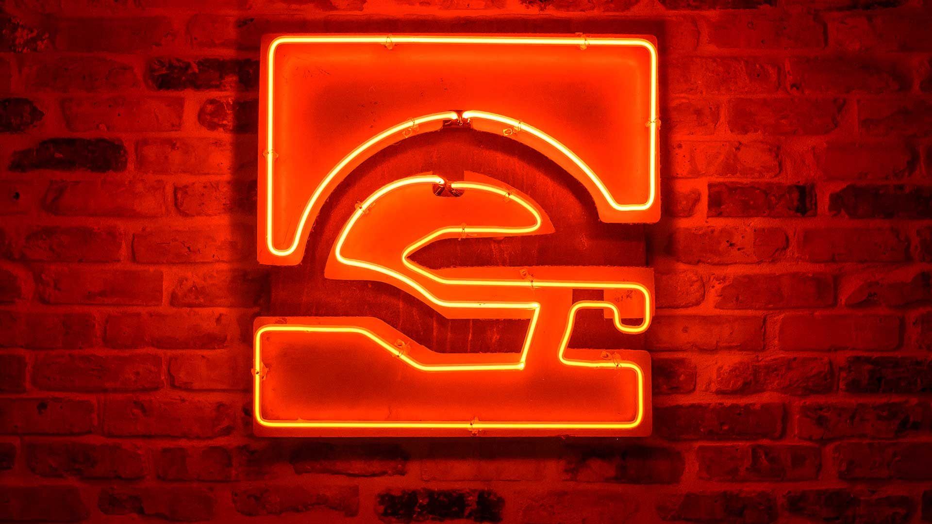 The monogram in neon on the brick