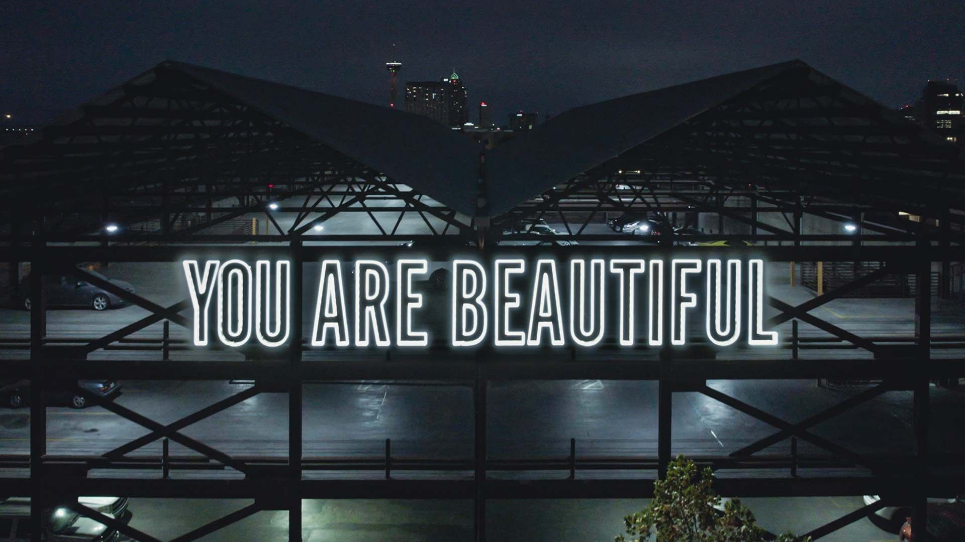 The You Are Beautiful letterforms lit above San Antonio